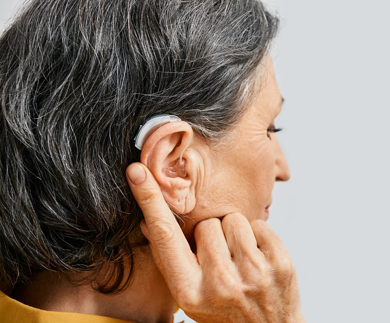 A woman from behind wearing a hearing aid on the right ear