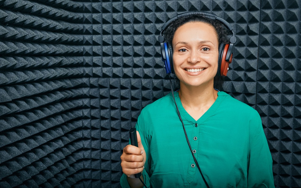 A woman in a green shirt taking a hearing test