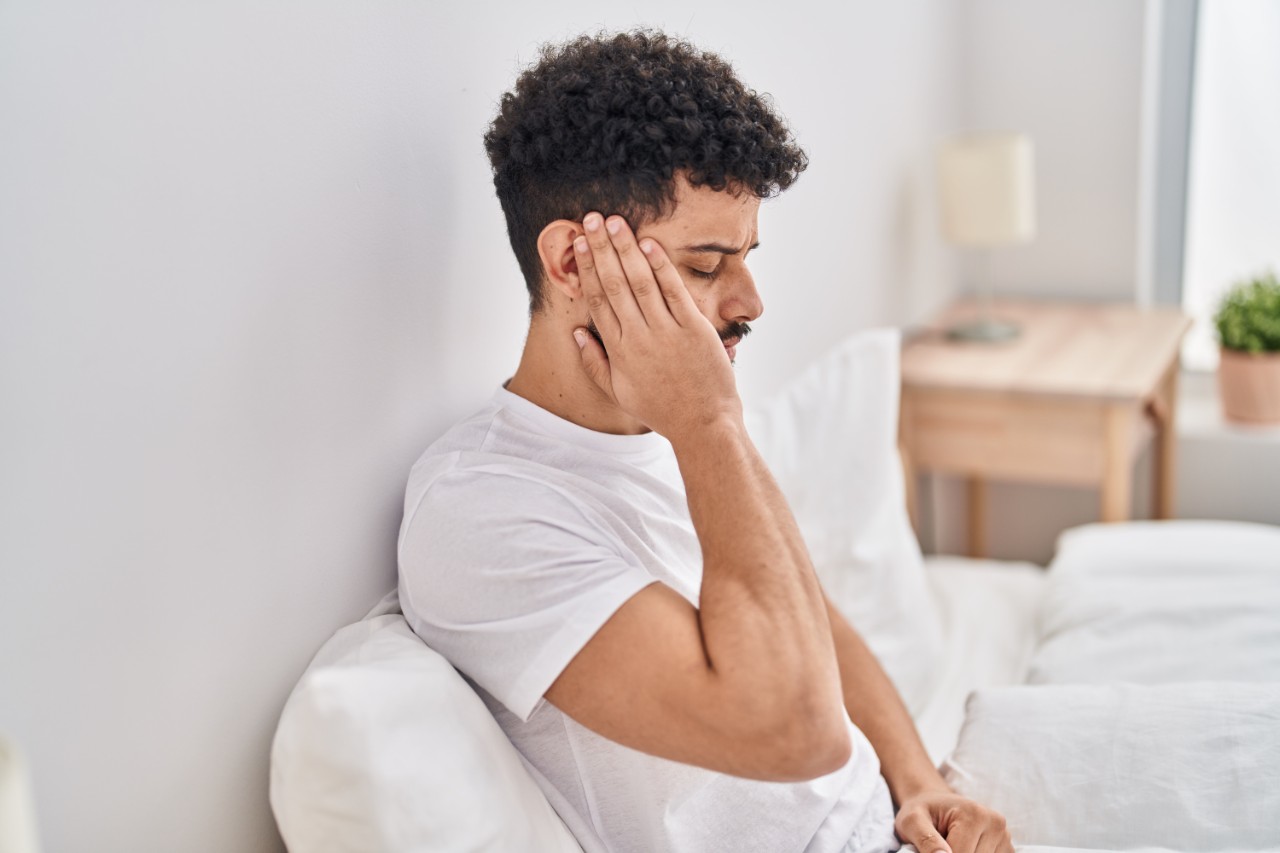 A man holding his ear in pain