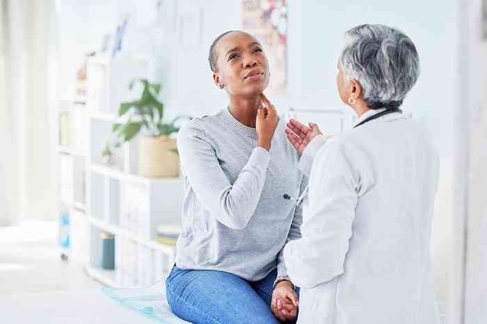 Patient showing lump behind the ear to the doctor