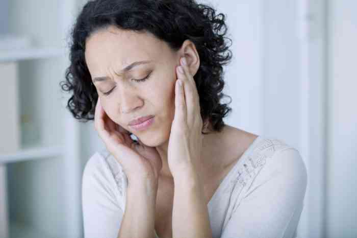 Woman touching her ears in pain