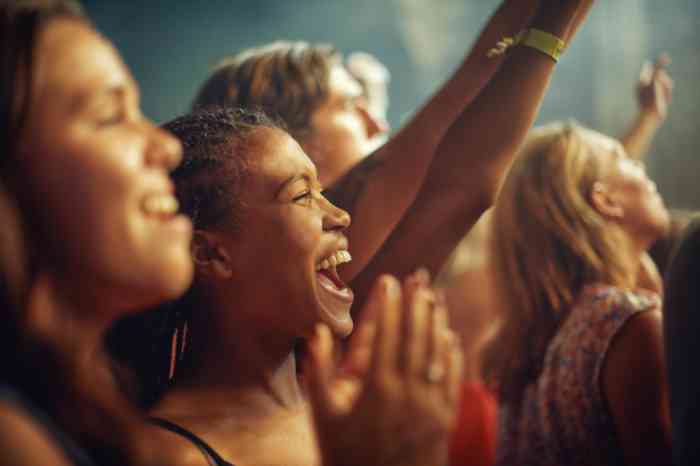 Group of girls at a concert, smiling and listening to music