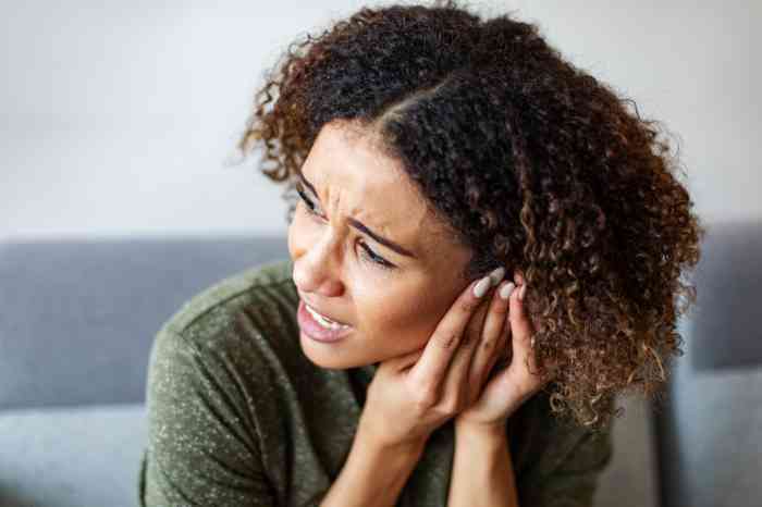 a woman holding her ear in pain