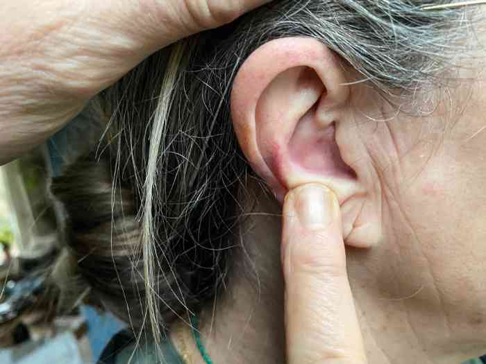 hand pointing to a woman's ear
