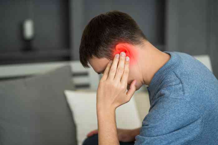 a man holding his ear in pain