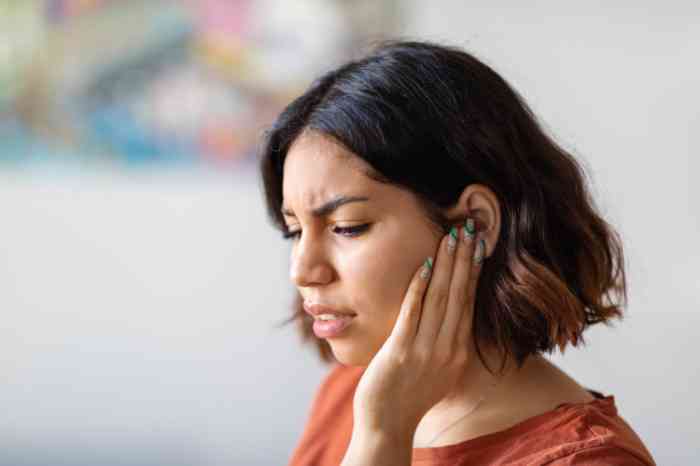 A woman holding his ear in pain