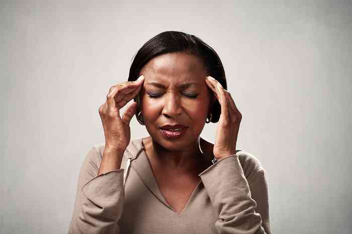 a woman holding her head in pain