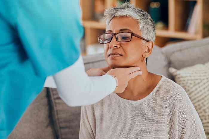 A doctor visiting a woman's neck and ears