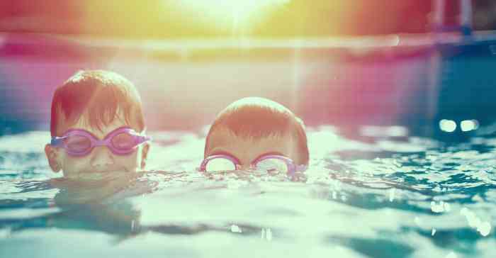 Two kids swimming in a pool