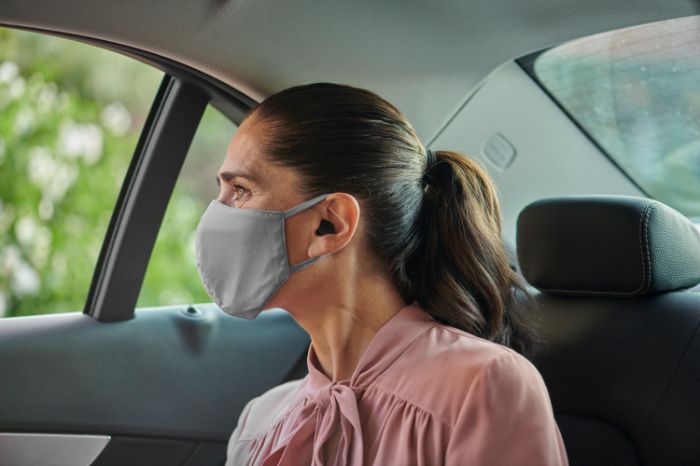 a woman wearing a face mask and a hearing aid