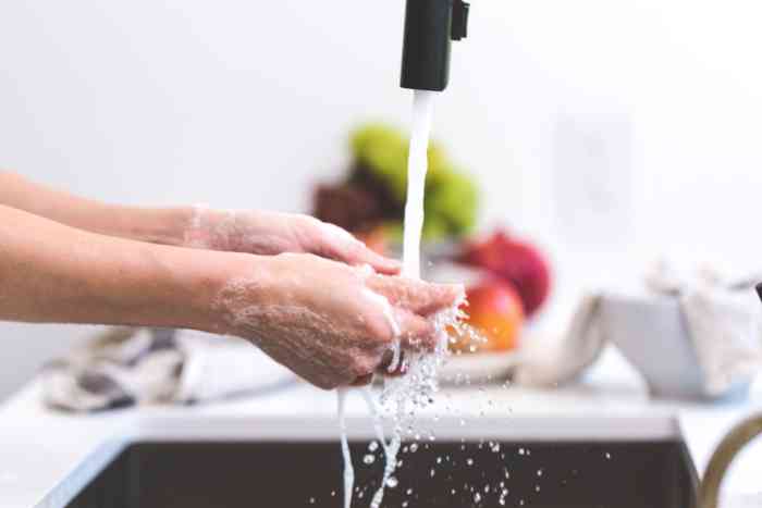 Woman washing her hands in the kitchen