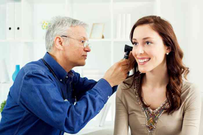 A doctor visiting a woman's ear