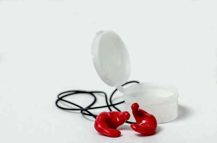 Red earplugs with a black cord and a white box