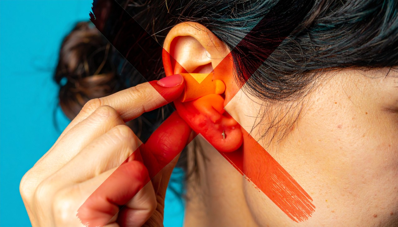 A red cross symbol over a woman inserting an earplug