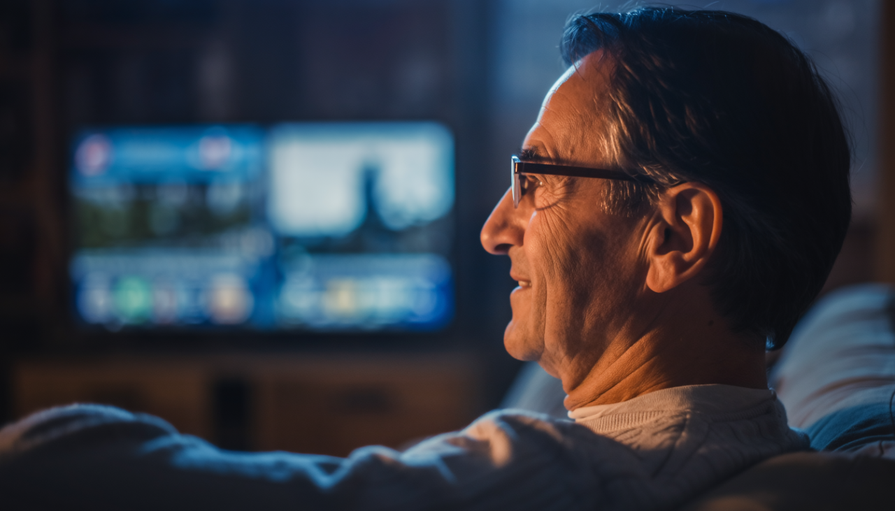 Un hombre con audifonos conectados a la tv