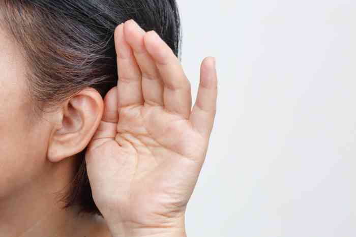 Close up of a hand close to a woman's ear