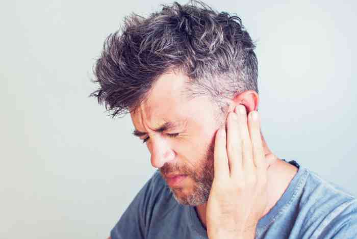 Young man expressing ear pain
