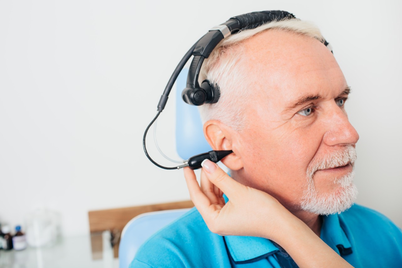 A man with a light blue shirt perfoming a hearing test