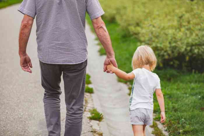 A grandfather walikg with his grandchild by his side