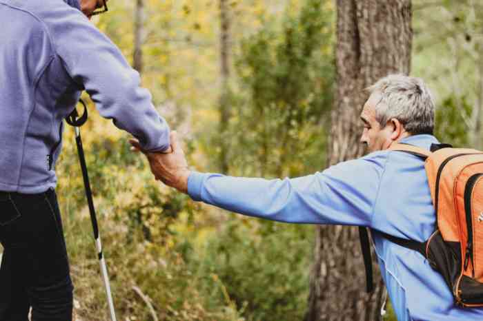 Lord helping a man with a backpack in the mountains