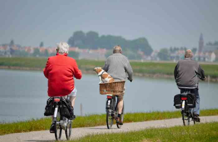 Tre signori vanno in bici lungo un fiume