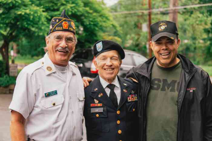 three old men in uniform in front of the camera