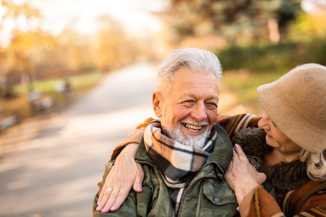 Elderly couple smiling outside