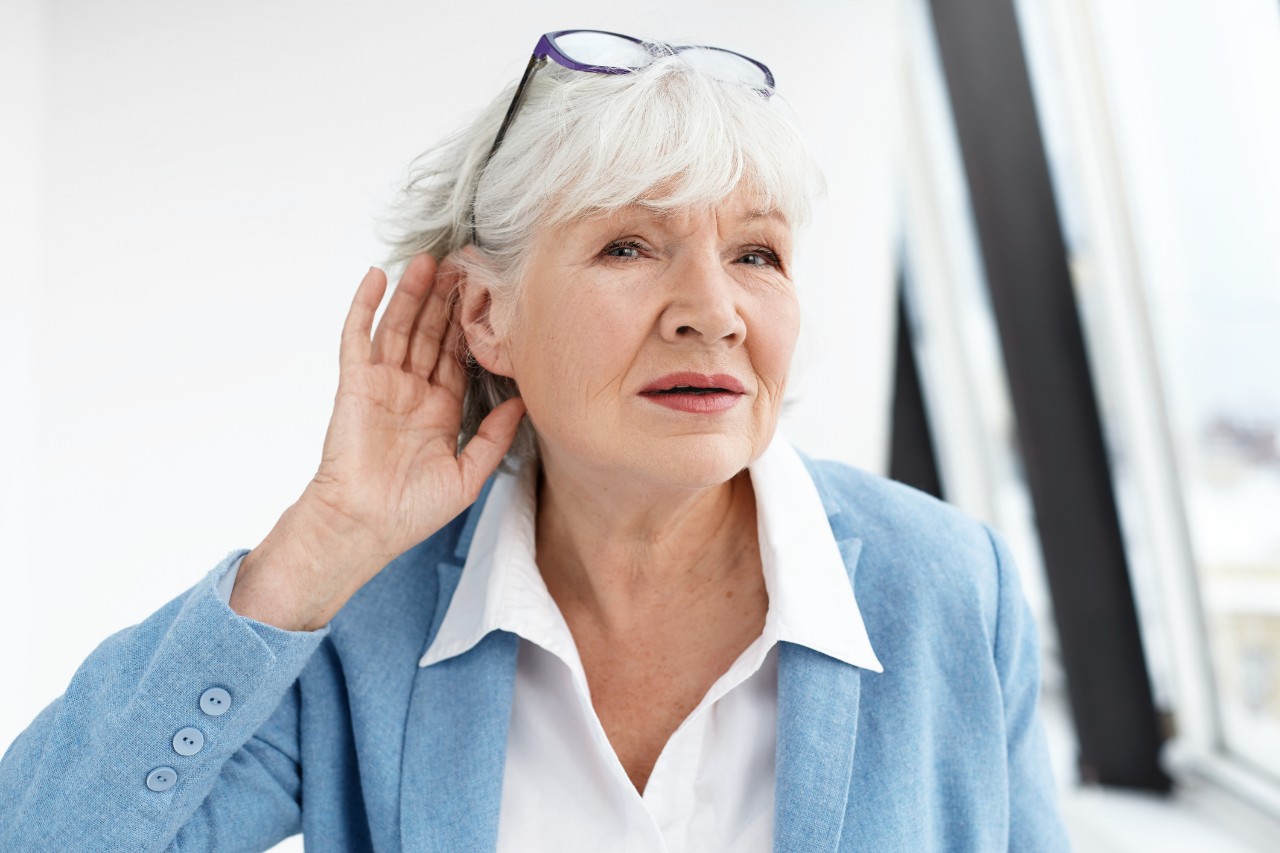  Ältere Frau demonstriert ihre Hörfähigkeit