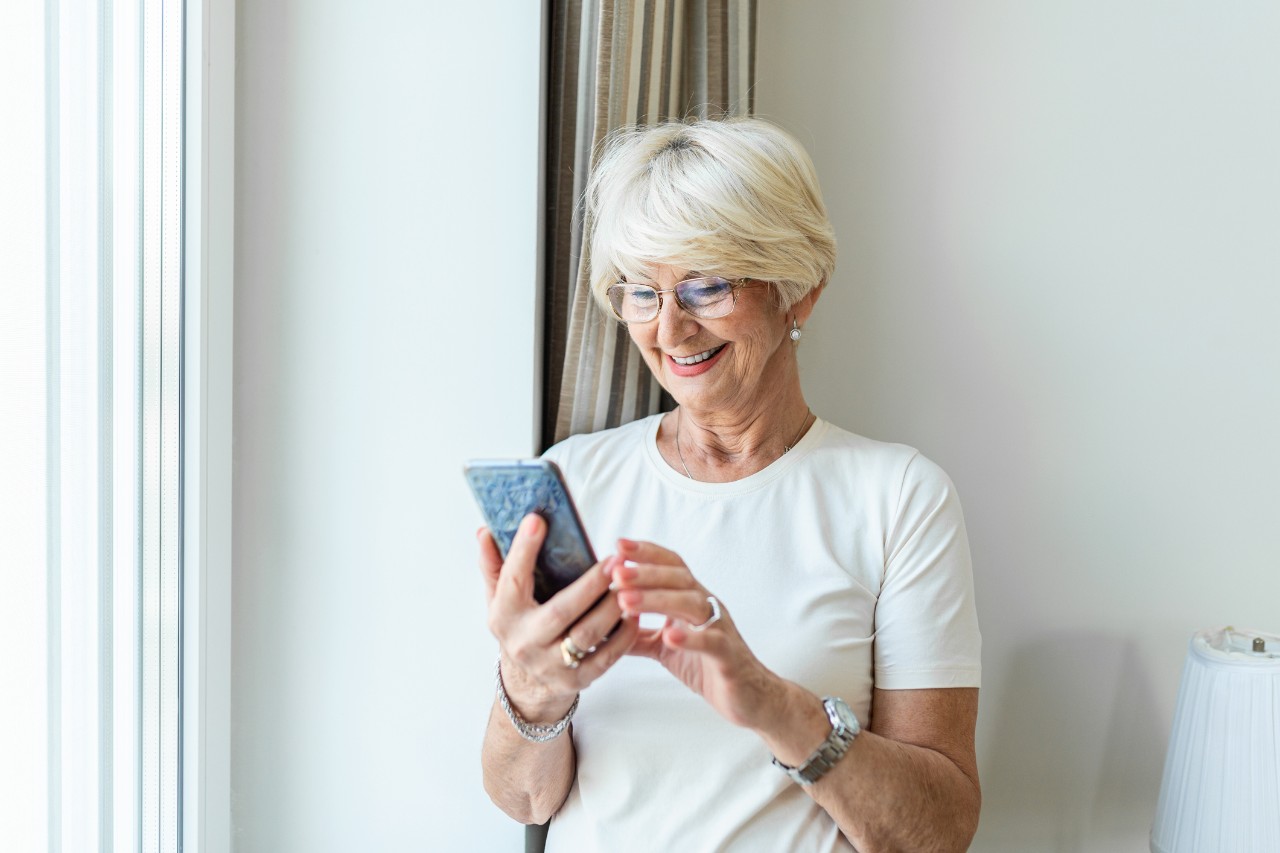 Elderly woman smiling at her phone