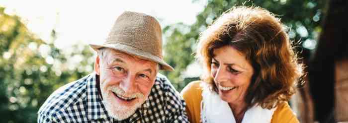 A man with a hat and a woman with a white shirt laughing