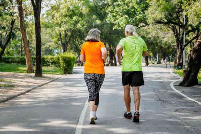 Due anziani corrono in un parco