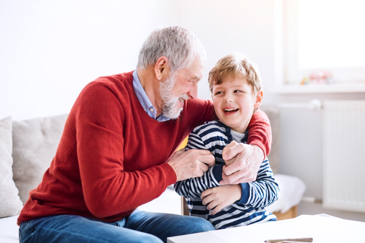 An old man with his grandson smiling at each other