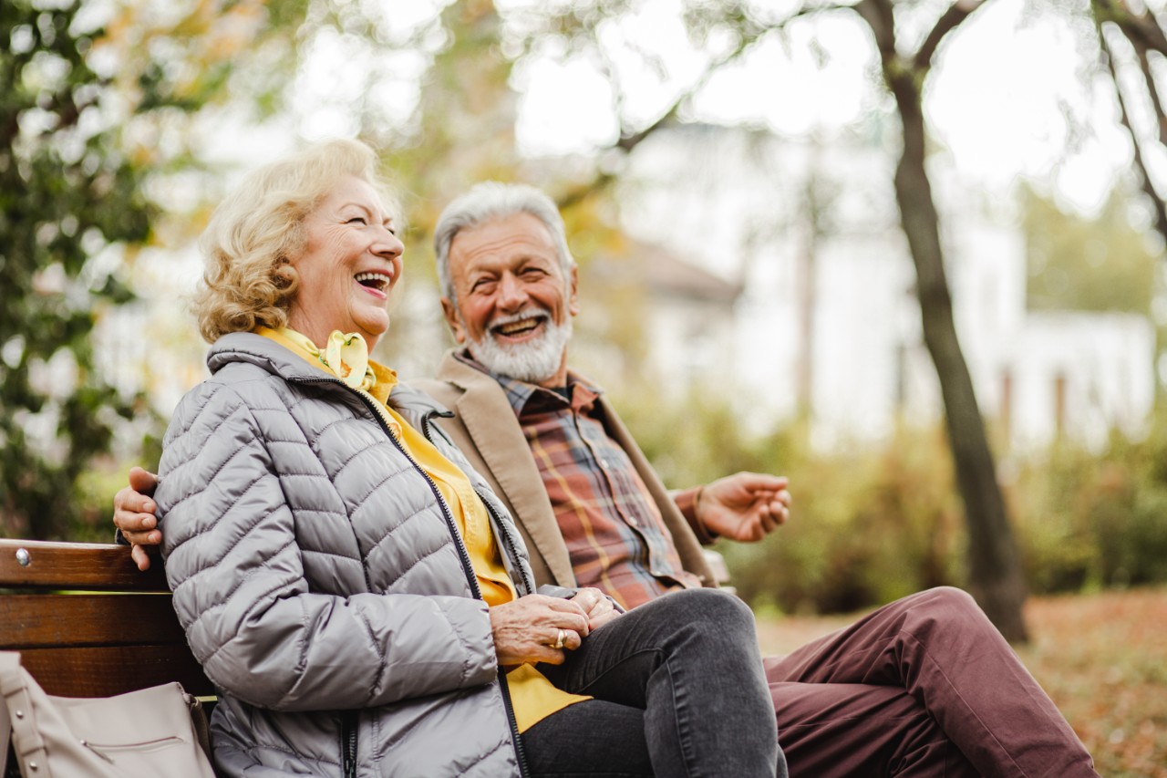 A couple laughing sitting in a park