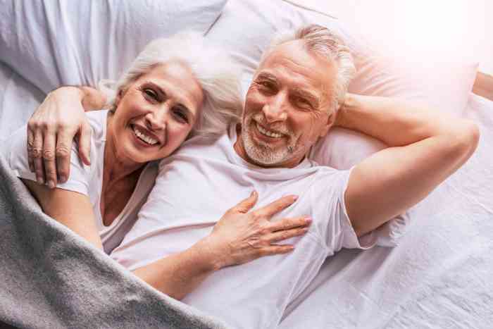 A couple in bed smiling 