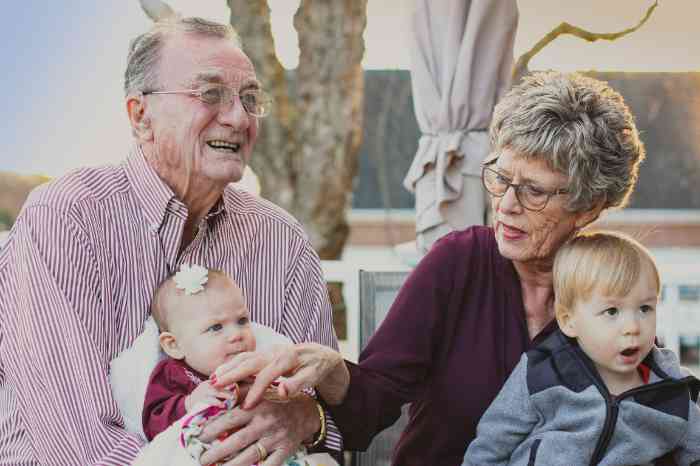 An old man laughing and playing with a kid