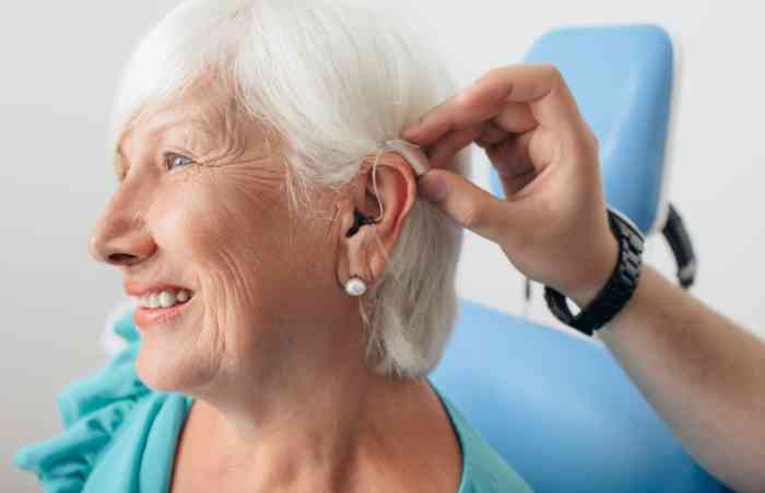 Profile of a woman smiling and wearing a hearing aid