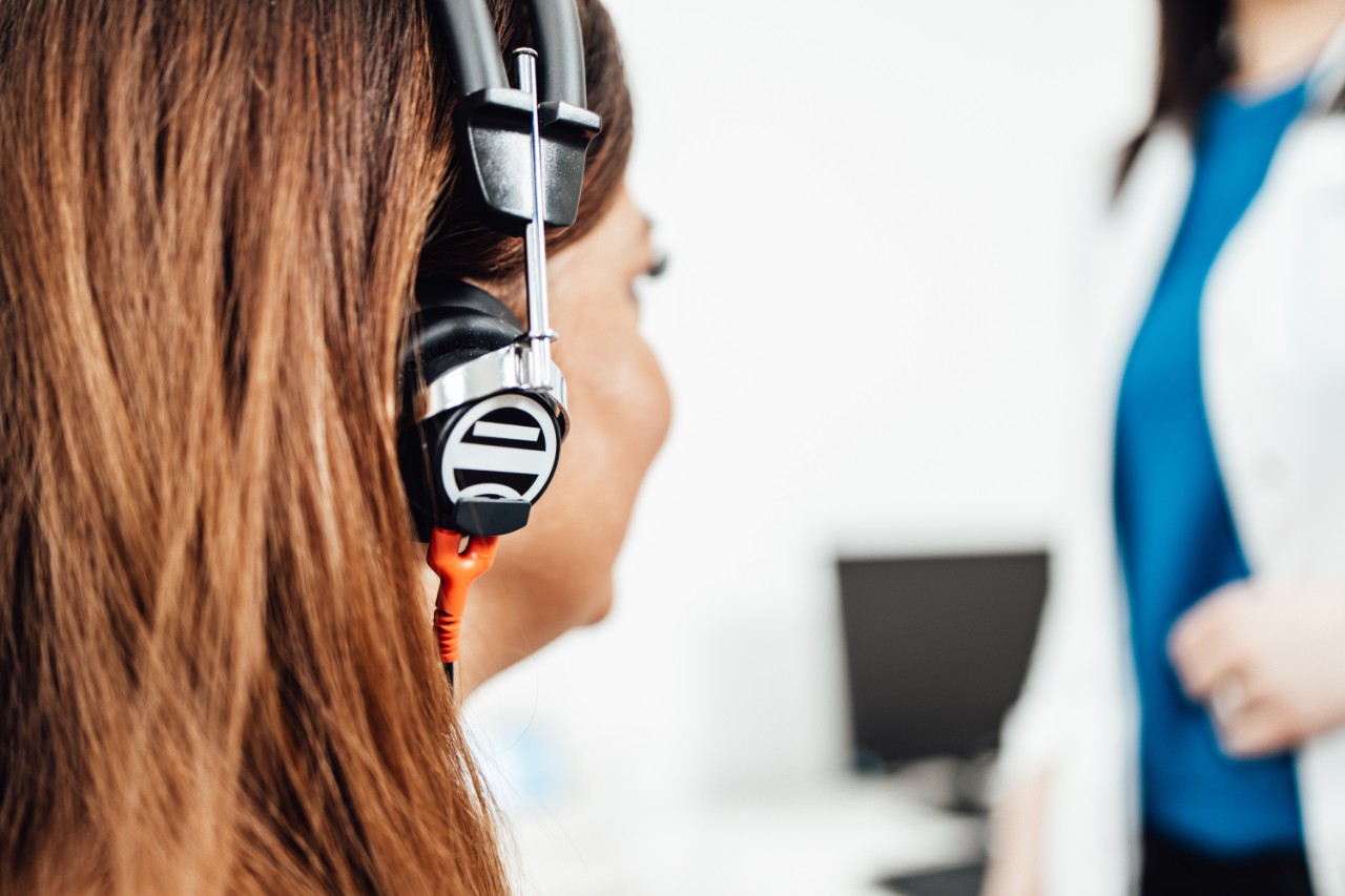 Woman wearing a headset, with another woman in the background faded out