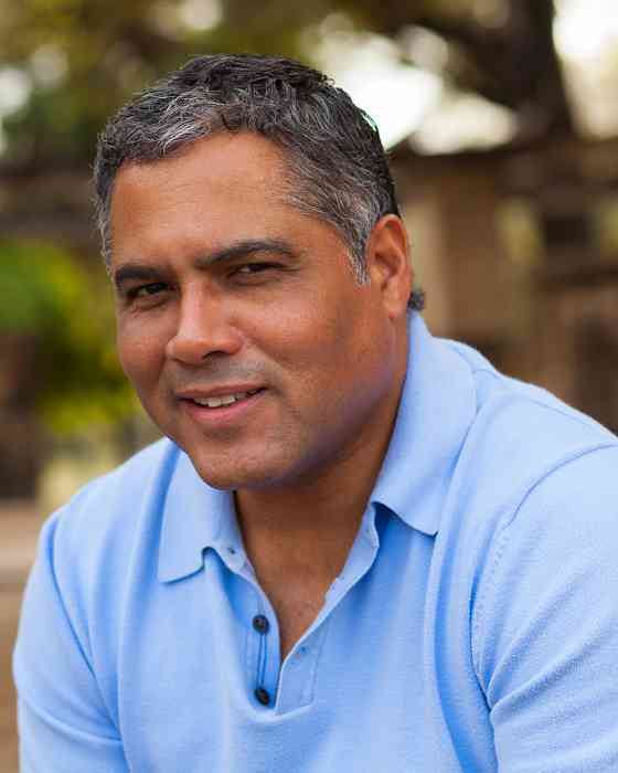 Man with a light blue polo smiling