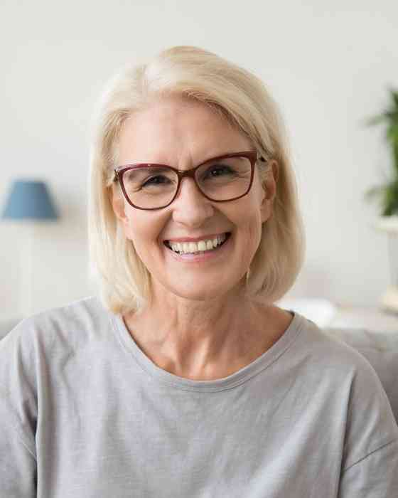 Donna bionda con gli occhiali sorridente